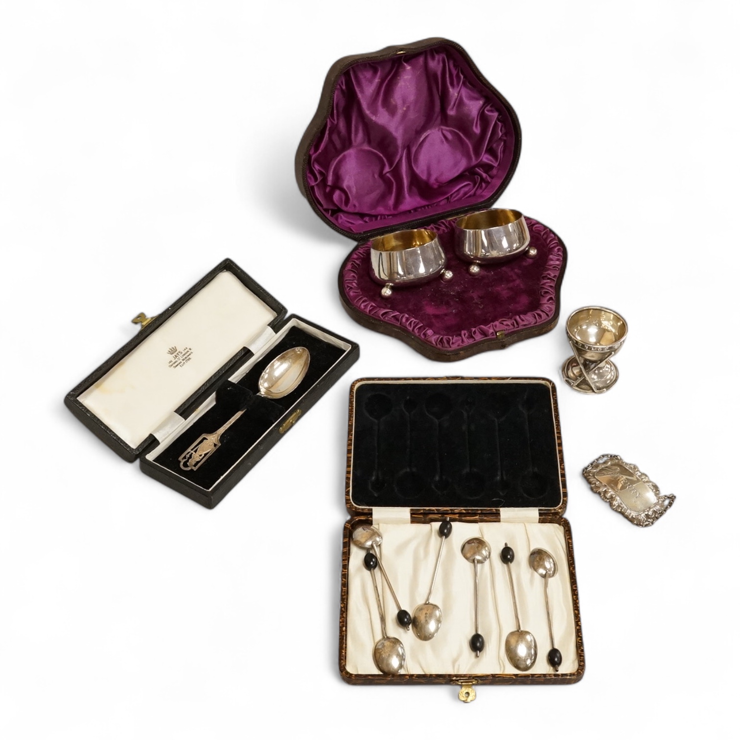 A cased pair of Victorian silver circular salts, by Edward Hutton, London, 1886, lacking spoons, together with a cased set of six silver bean end coffee spoons, a cased silver spoon, a small silver 'Dunlop Golf Ball Hole
